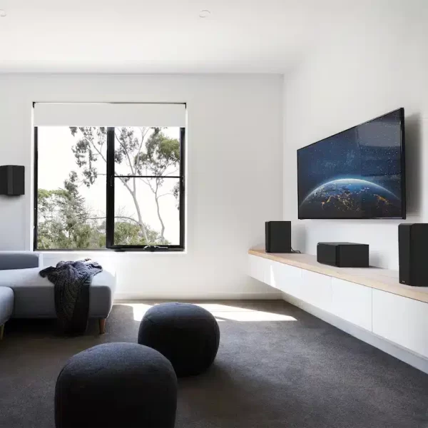 RP-500C-II-sitting-on-a-white-and-wood-colored-credenza-under-a-TV-with-grille-on-in-front-of-some-interesting-furniture